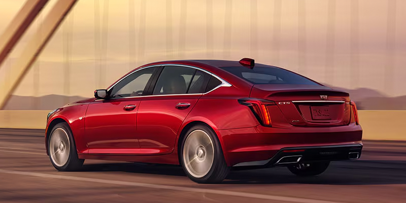 Side profile of a red Cadillac CT5 driving across bridge.