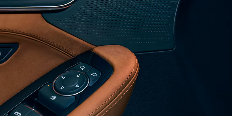 Close-up view of Cadillac CT5 interior door armrest controls.
